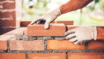 Hände, die eine Wand mauern