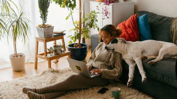Eine Frau kuschelt mit Ihrem Hund im Wohnzimmer