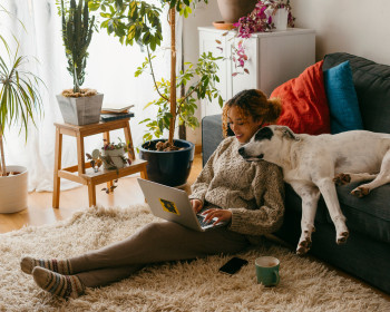 Eine Frau kuschelt mit Ihrem Hund im Wohnzimmer