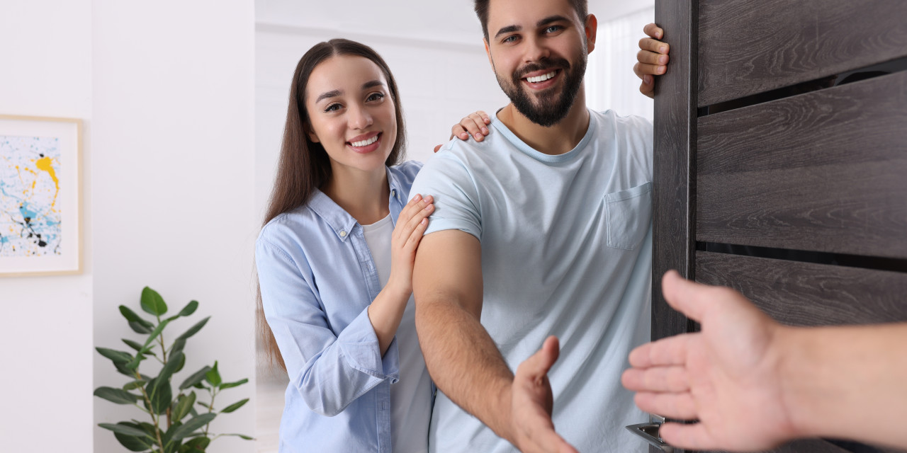 Zwei Personen Begrüßen jemanden an der Tür