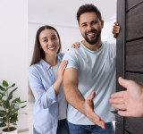 Zwei Personen Begrüßen jemanden an der Tür