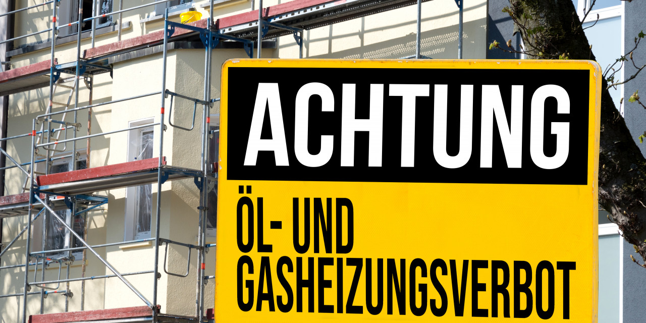 Achtungsschild vor einem eingerüsteten Haus 