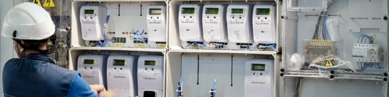 Techniker vor Schrank mit Stromzählern