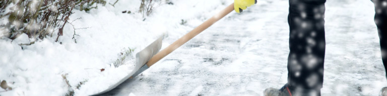 Weg wird mit Schneeschippe geräumt