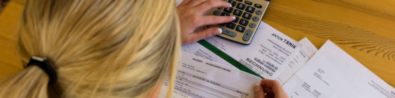 Frau liest Abrechnungs-Belege