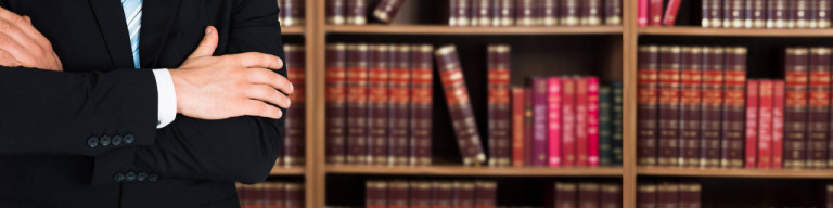 Rechtsanwalt vor Bücherregal