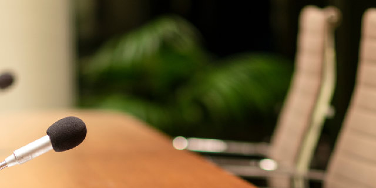 Mikrofone an einem Podium mit Stühlen