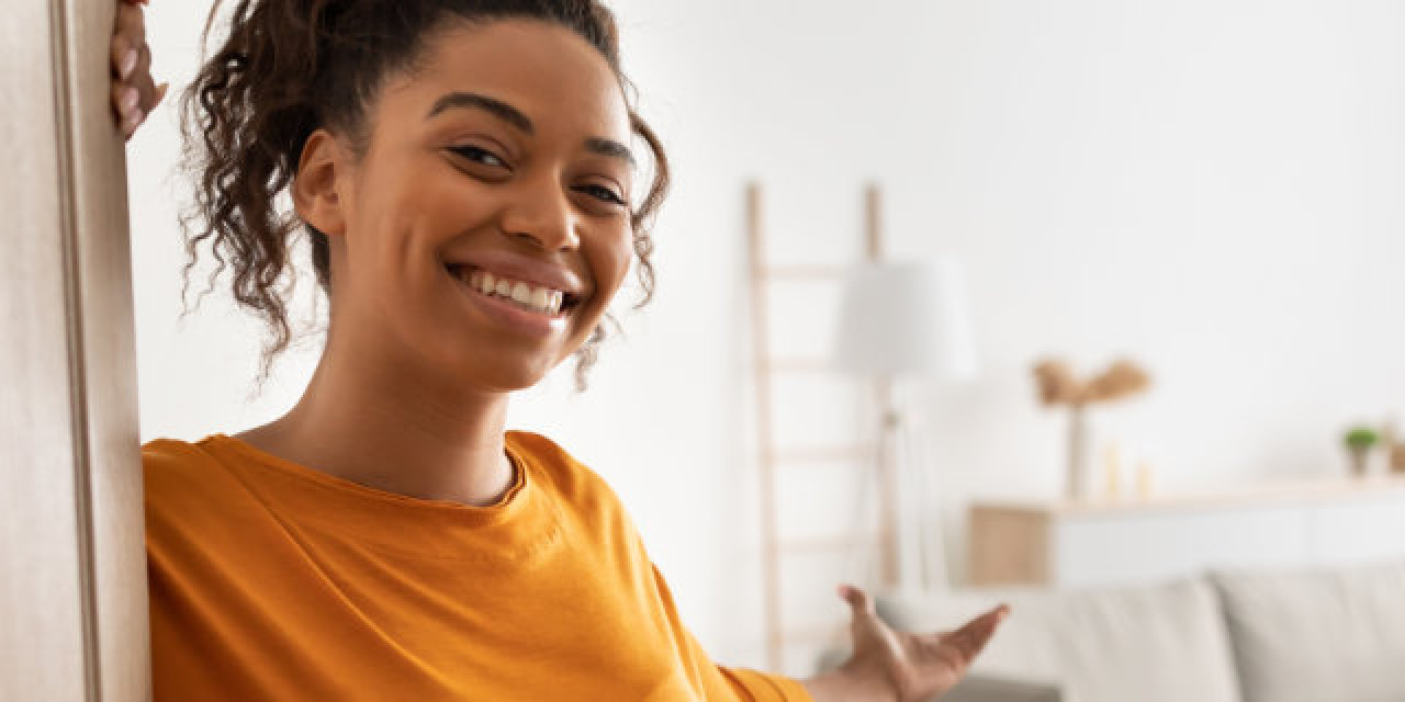 Frau öffnet Wohnungstür