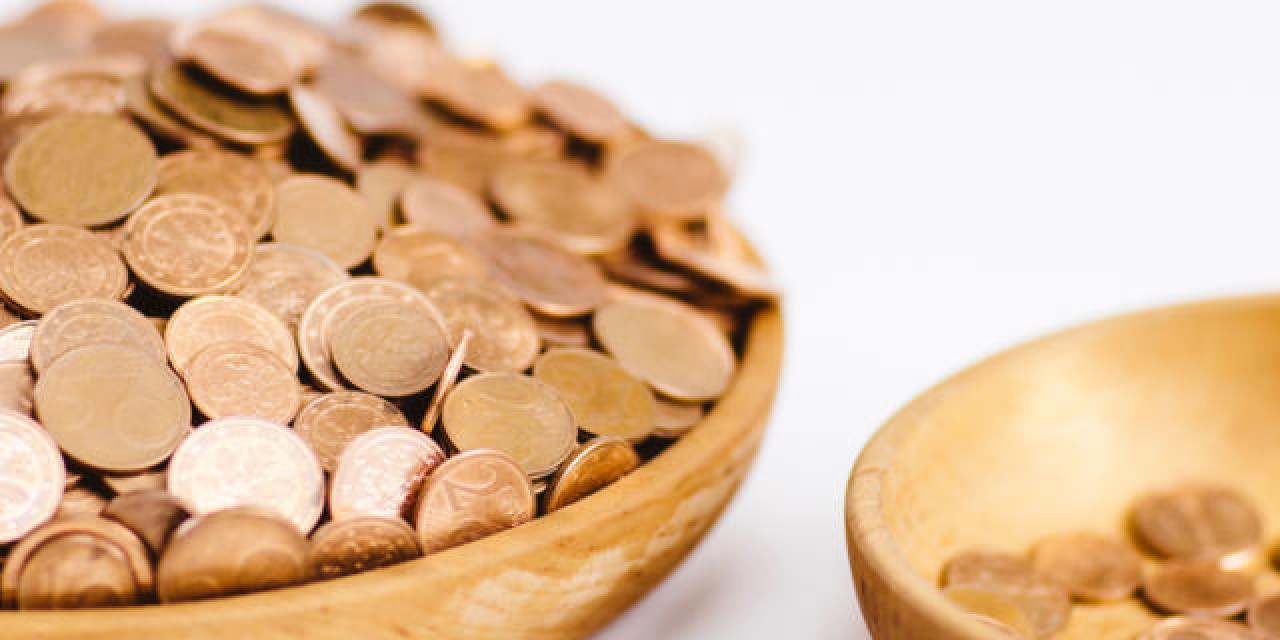 Ungleich verteilte Geldmünzen in Holzschalen