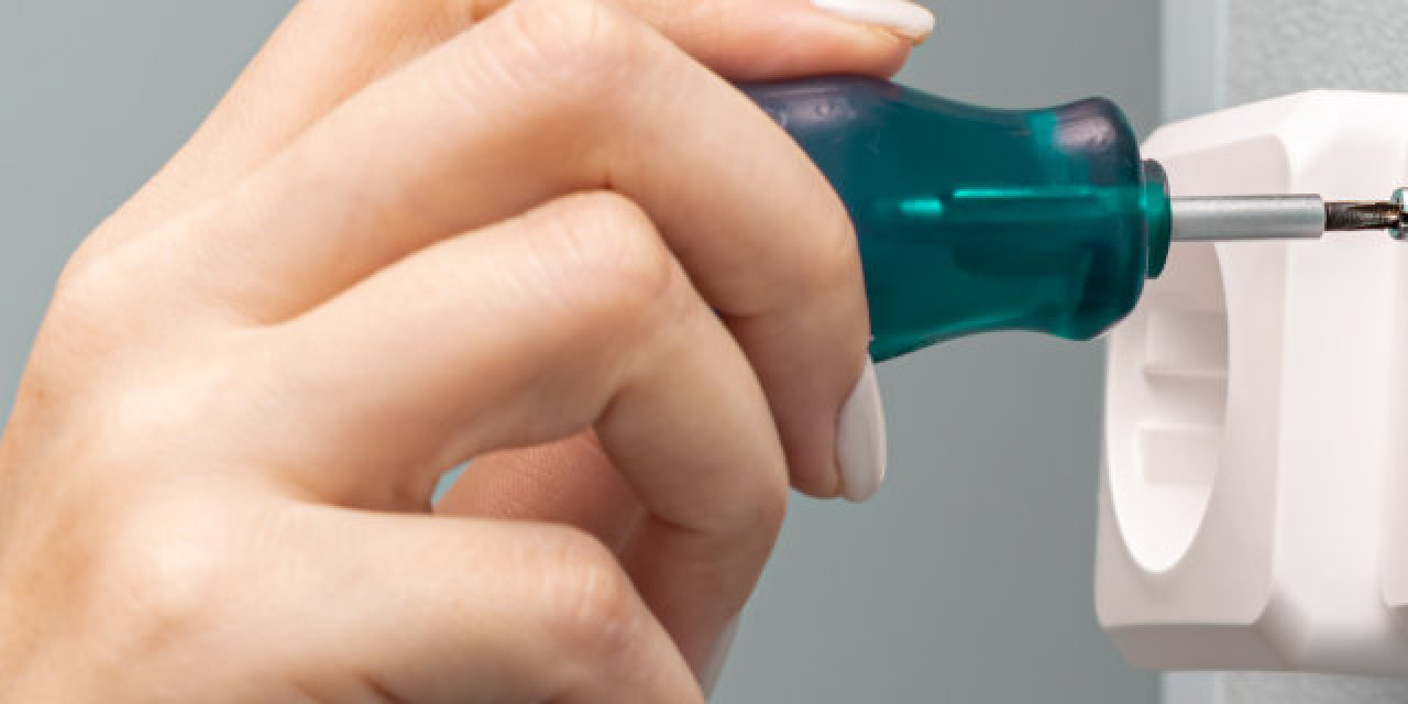 Fernsehkabel-Wanddose wird mit Schraubenzieher repariert