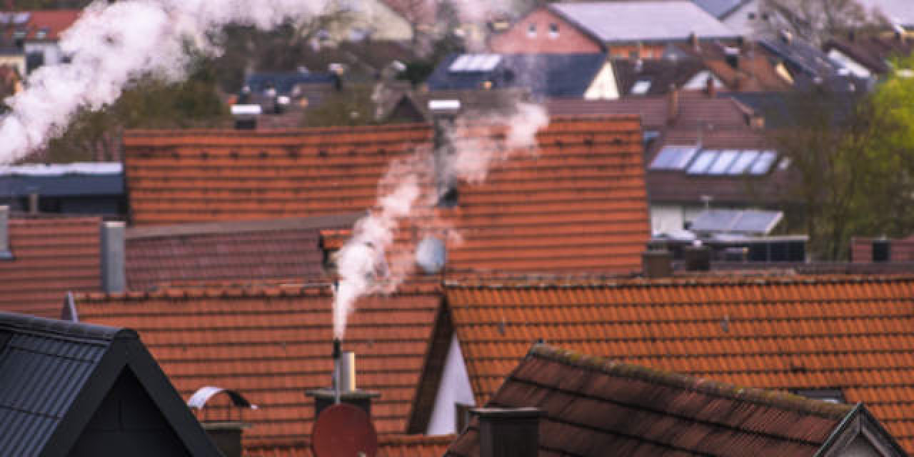 Rauchende Schornsteine über Wohngebiet