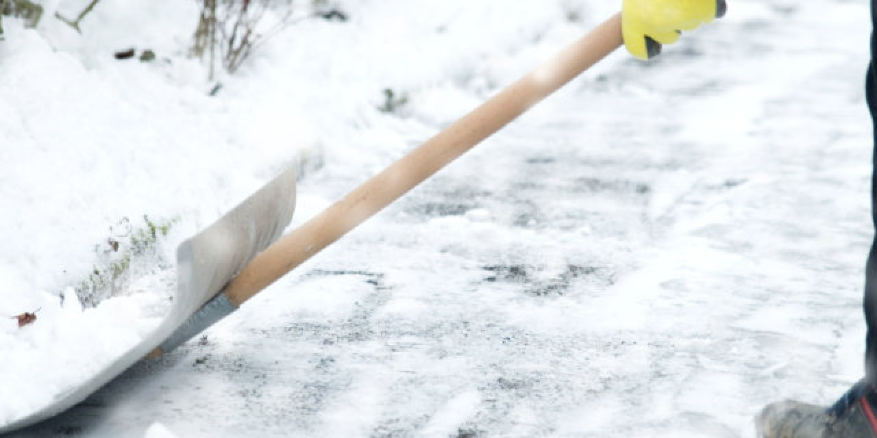 Weg wird mit Schneeschippe geräumt