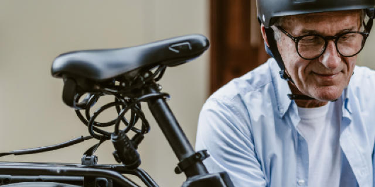 Älterer Mann wechselt E-Bike-Akku