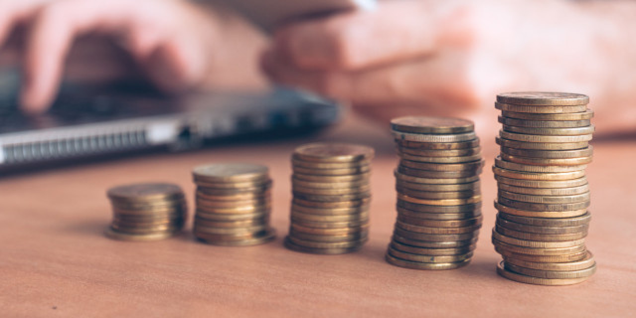 Münzstapel vor Laptop