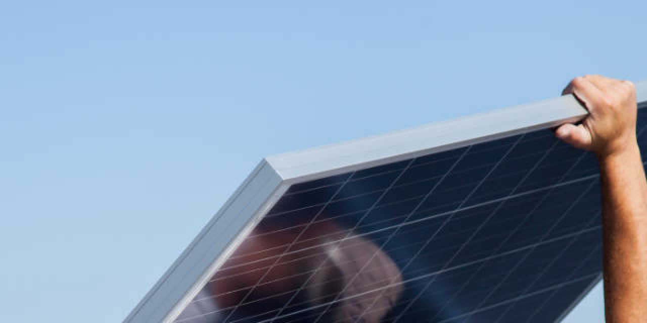 Mann trägt Photovoltaik-Panel