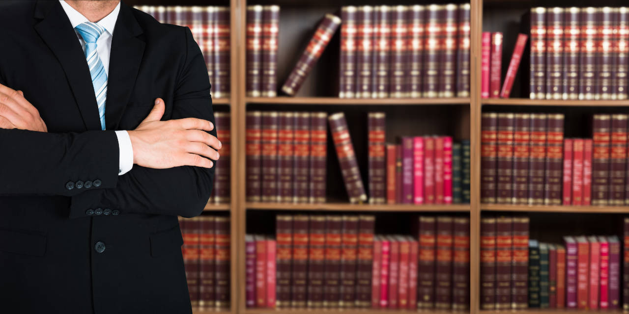 Rechtsanwalt vor Bücherregal