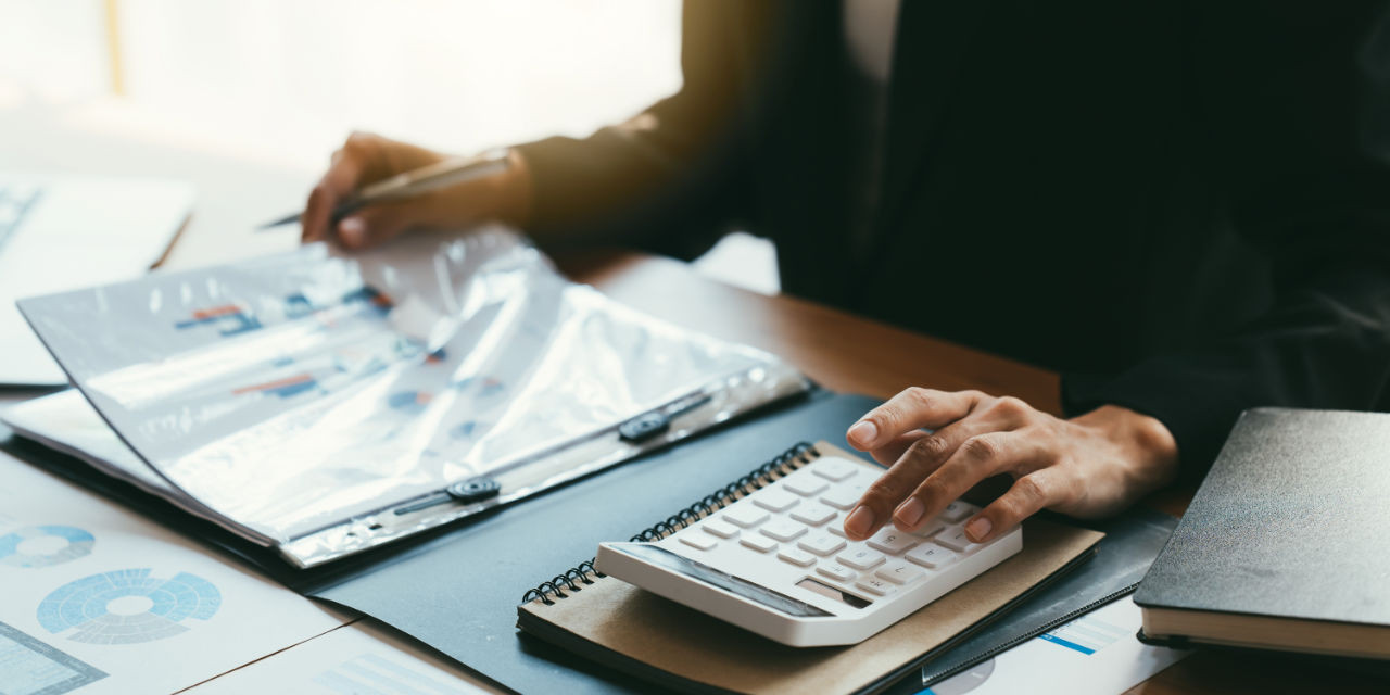 Mann mit Taschenrechner bei Abrechnung