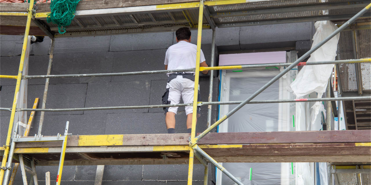 Arbeiter dämmen Fassade eines Hauses