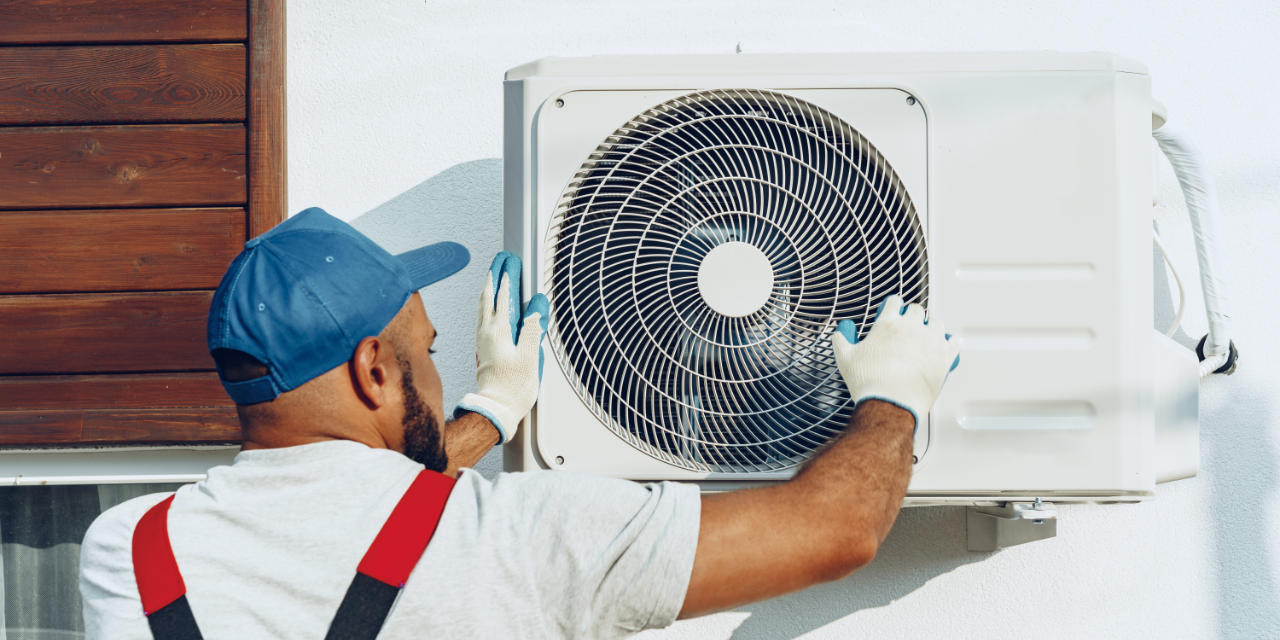 Installateur montiert Außeneinheit einer Split-Klimaanlage