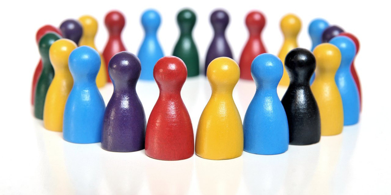 Vielfarbige Spielfiguren bilden einen Versammlungskreis