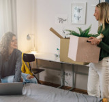 Mitbewohnerin zieht mit Umzugskartons in Wohnung ein