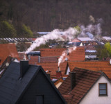 Rauchende Schornsteine über Wohngebiet