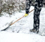 Weg wird mit Schneeschippe geräumt