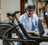Älterer Mann wechselt E-Bike-Akku