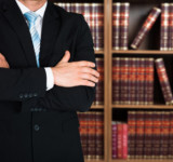 Rechtsanwalt vor Bücherregal