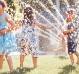 Kinder die Im Garten mit Wasser spielen