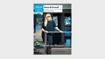 Frau in schwarzer Kleidung steht vor einem modernen Gebäude und hält ein Geländer mit einer Hand