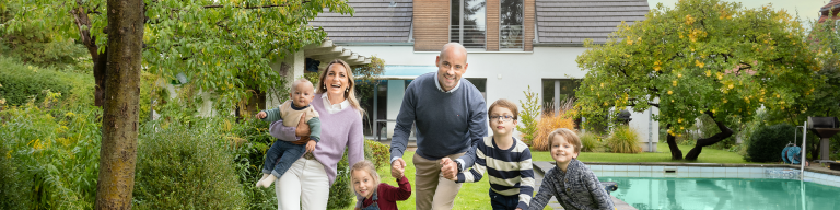 Glückliche Familie im Garten mit Pool