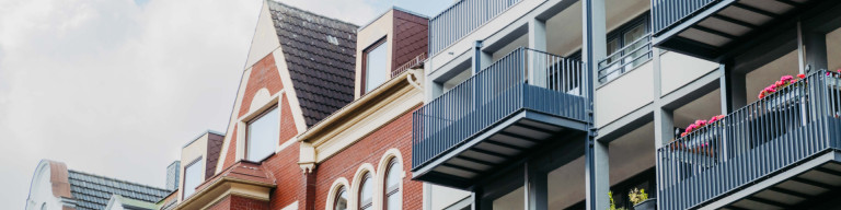 Altbau und Neubau mit Himmel