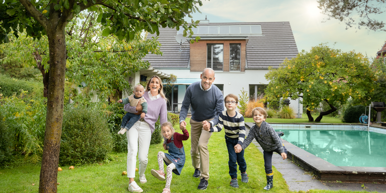 Glückliche Familie im Garten mit Pool