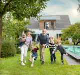 Glückliche Familie im Garten mit Pool