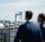 Zwei Köpfe mit Blick über die Dächer von Kiel