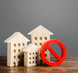 Mehrfamilienhäuser und rotes Verbotssymbol NEIN. 