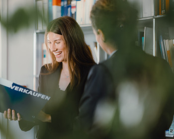 Eine Frau mit einer Verkaufsmappe und eine Frau von Hinten