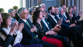 Gäste und Podiumsteilnehmer reagieren mit Applaus und guter Stimmung auf die Beiträge des Abends.