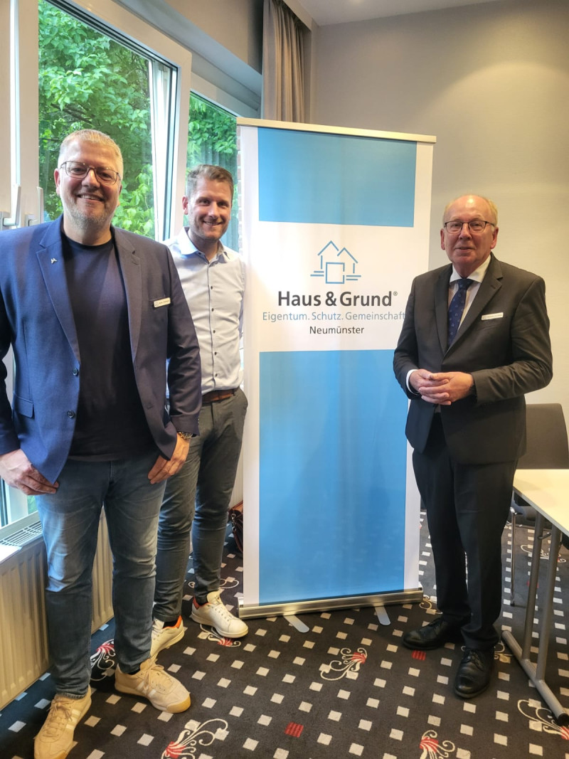 Die Herren Christians, Vogler und Prühs vor einem Haus & Grund Rollup