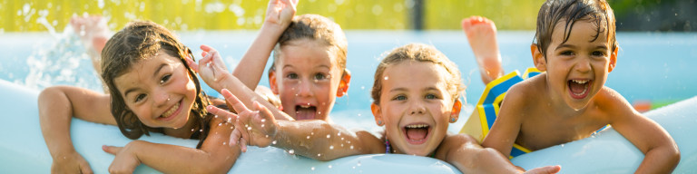 Kinder plantschen freudig im Plastik-Swimmingpool